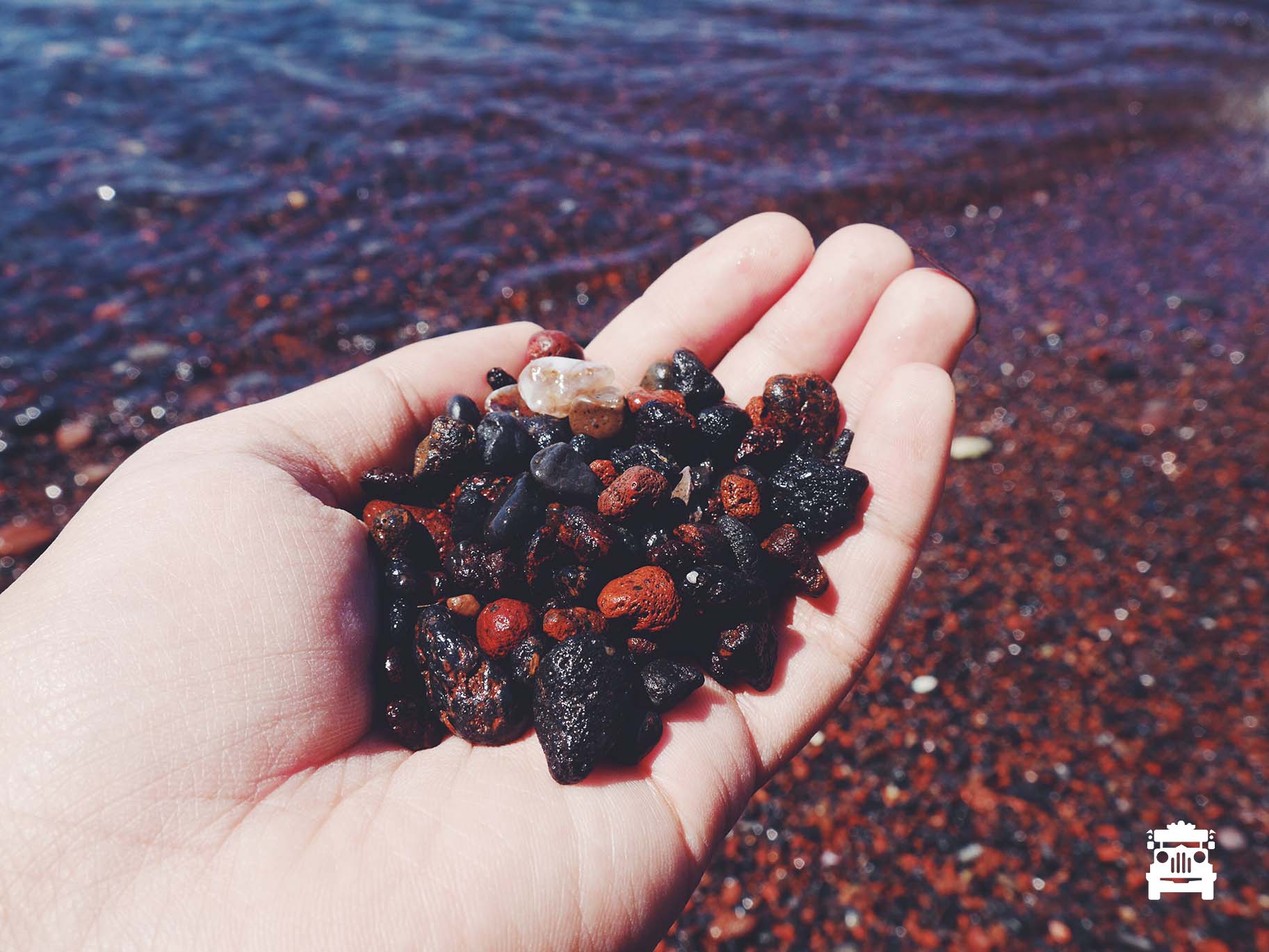 Red and black pebbles = Red beach